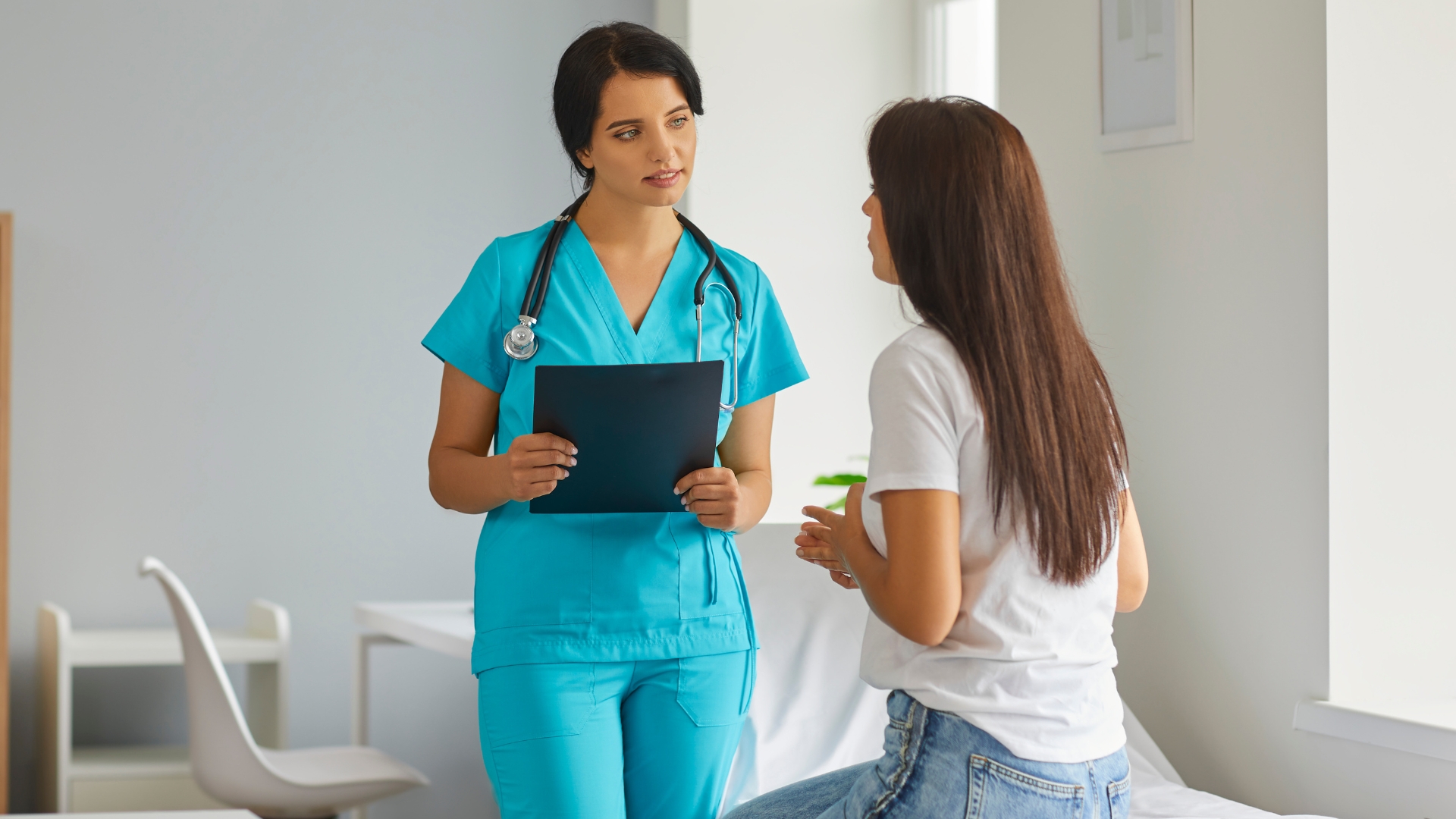 Female GP talking with a woman patient during a women's health consultation
